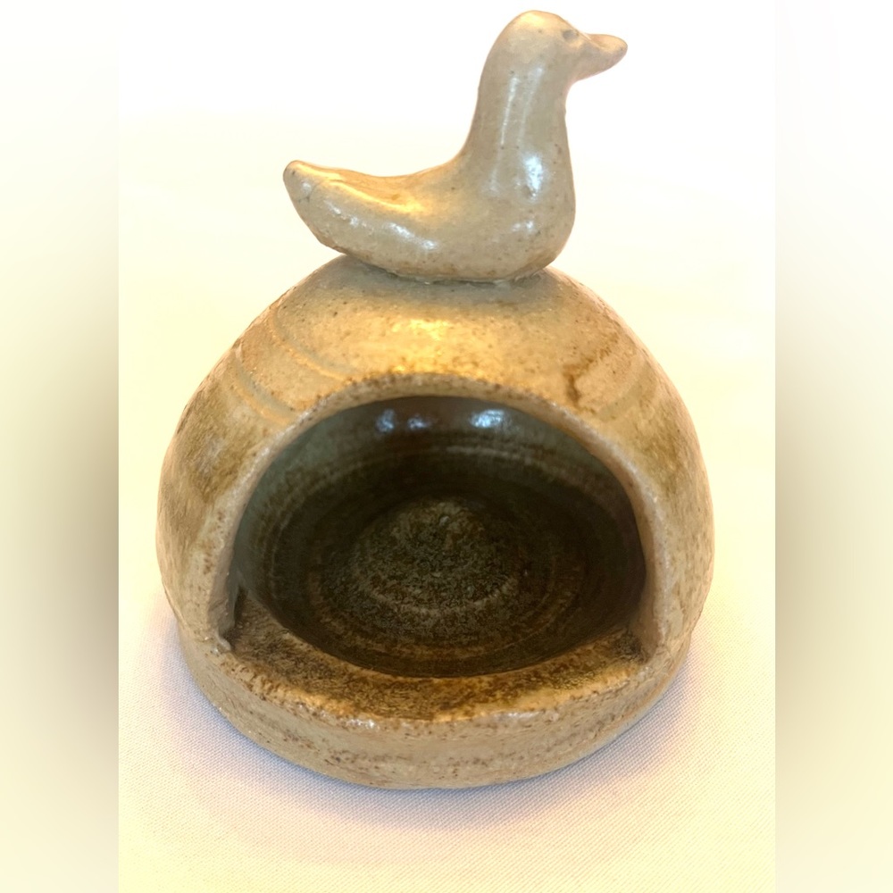 Vintage handmade pottery piece with bird